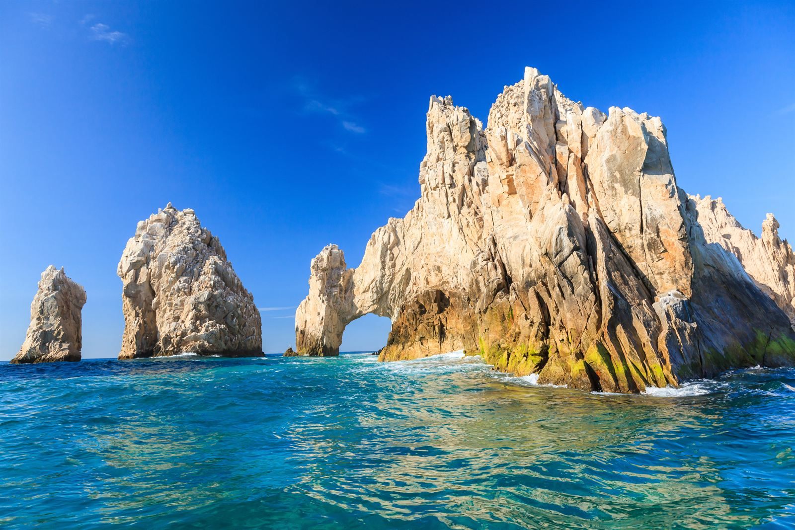 The rock arch and sea stacks at Land's End, Cabo San Lucas, rising from clear blue water
